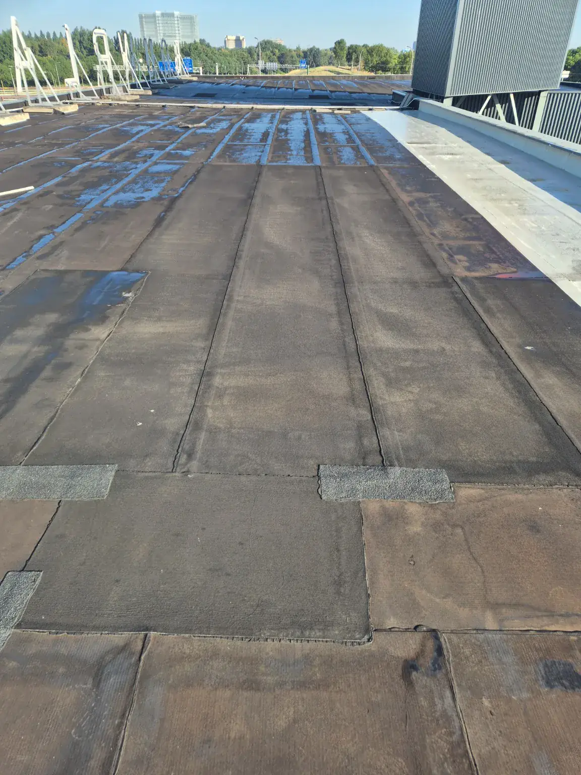 Verouderd bitumen dak voor de start van de renovatie