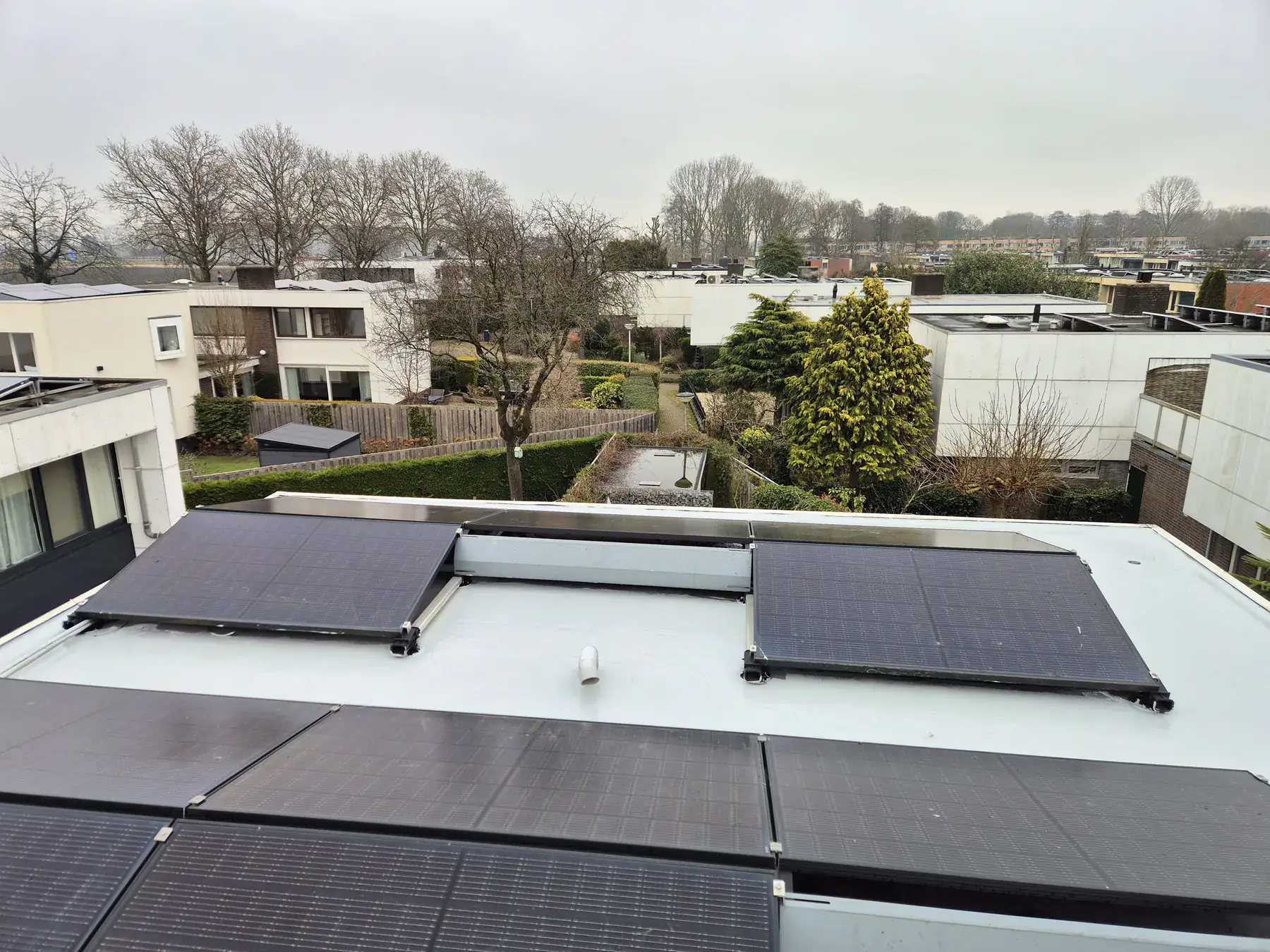 Witte dakcoating op een plat dak rond zonnepanelen