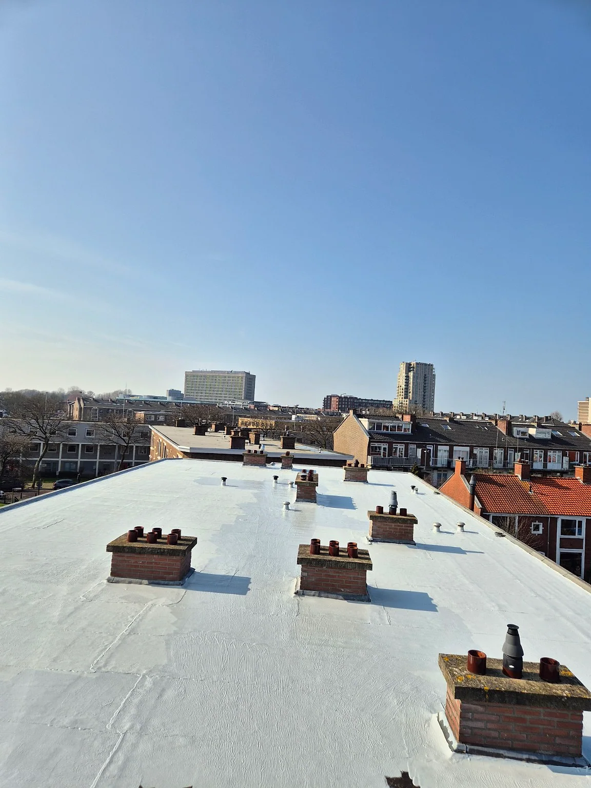 Gerenoveerd wit dak van een VvE-woongebouw