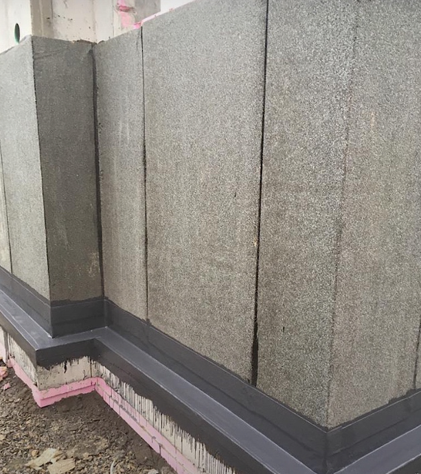 Sokkel en gebouwvoet voorzien van een doorlopende vloeibare afdichting