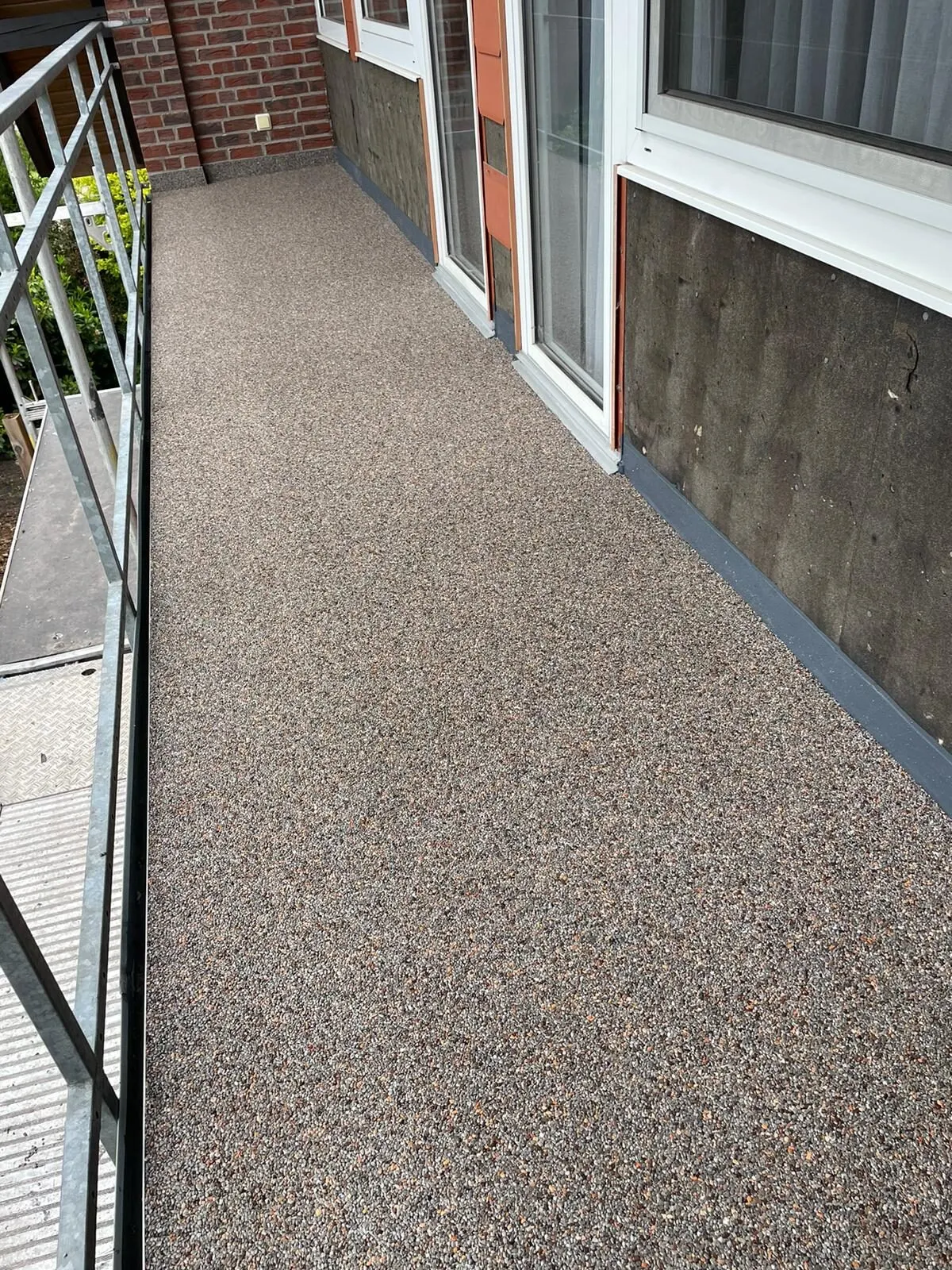 Balkon met steentapijt boven een waterdichte vloeibare systeemlaag